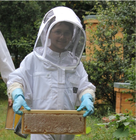 Du miel, et un jeune apiculteur heureux